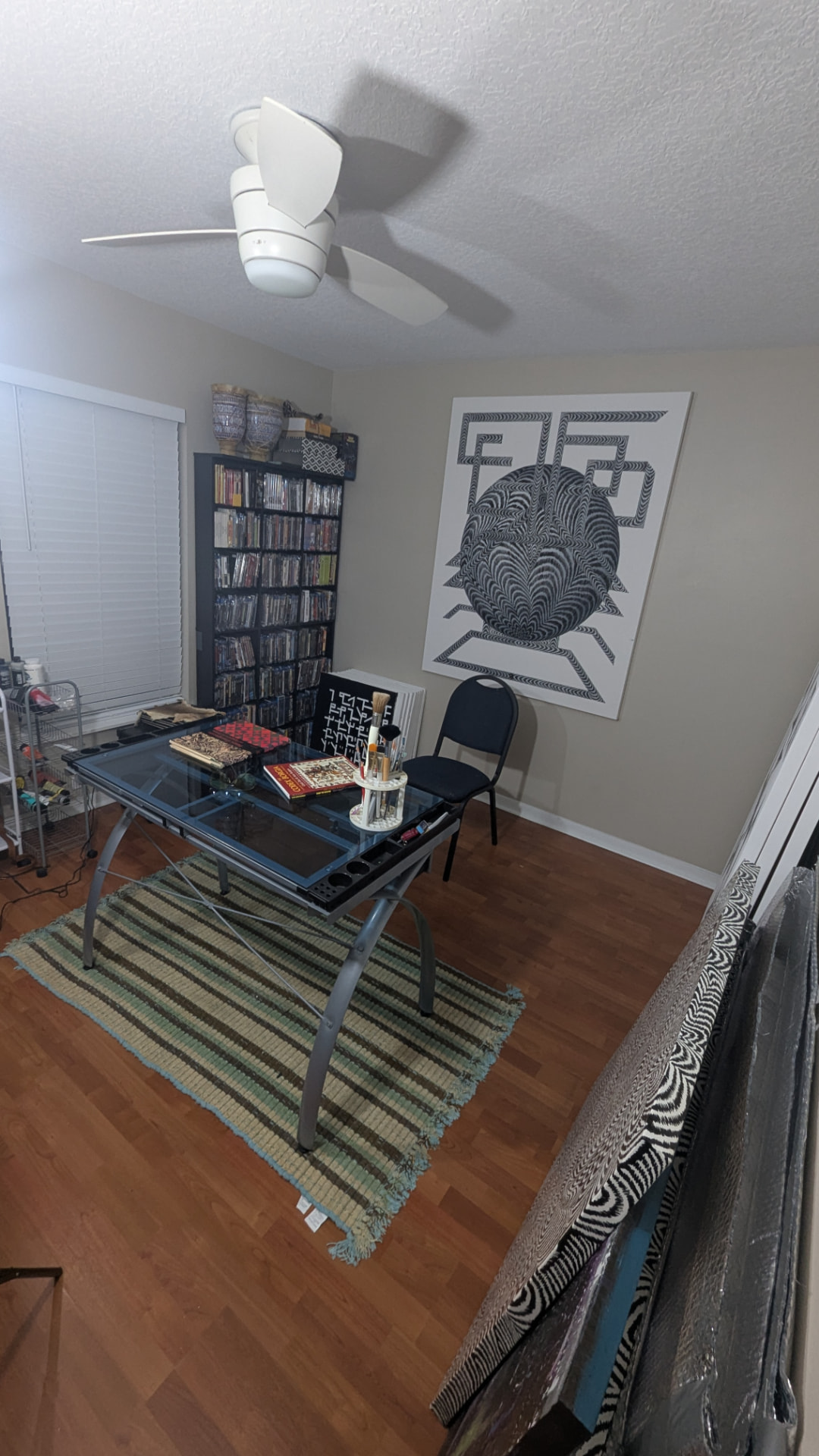 Estudio de trabajo con obras en proceso, materiales y una pieza abstracta en la pared